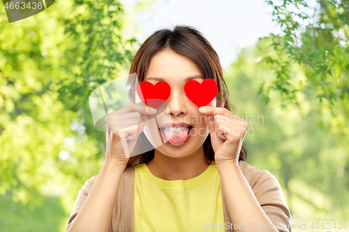 Image of woman with eyes of hearts over natural background