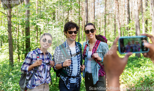 Image of friends with backpacks being photographed on hike