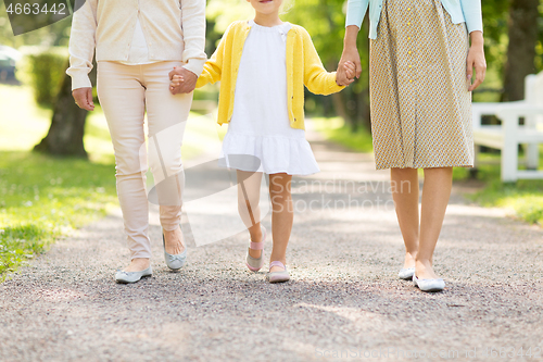 Image of mother, daughter and grandmother walking at park