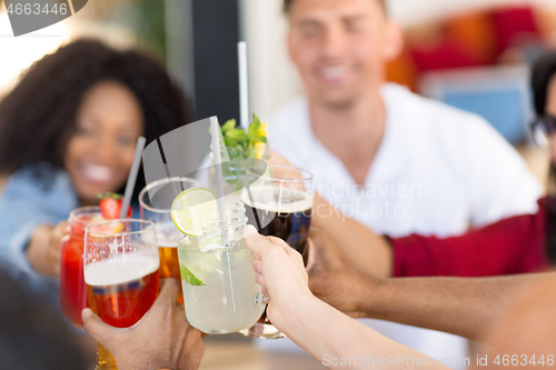 Image of friends clinking glasses at bar or restaurant