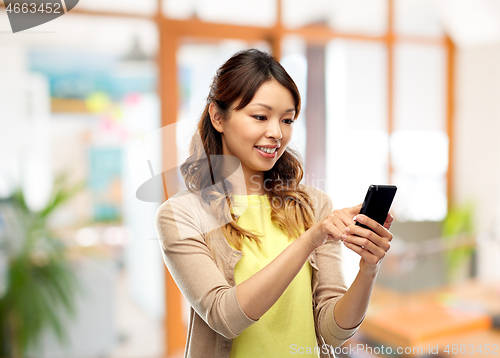 Image of happy asian woman using smartphone