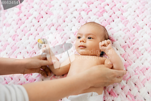 Image of sweet baby girl lying on knitted plush blanket