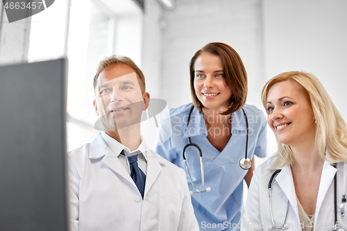 Image of group of doctors with computer at hospital