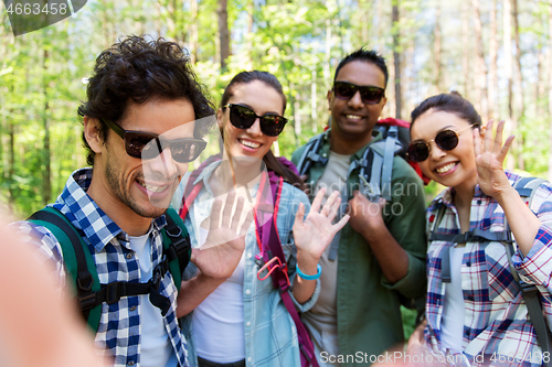 Image of friends with backpacks hiking and taking selfie