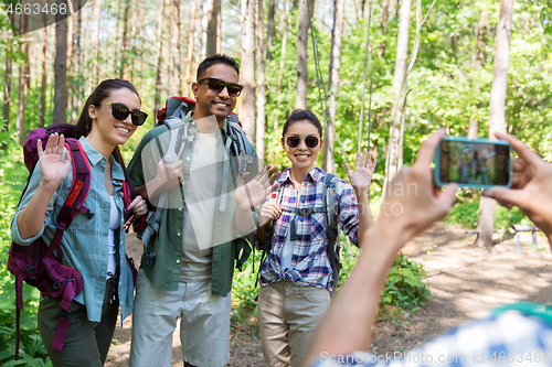 Image of friends with backpacks being photographed on hike