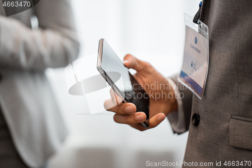 Image of businessman with smartphone at business conference