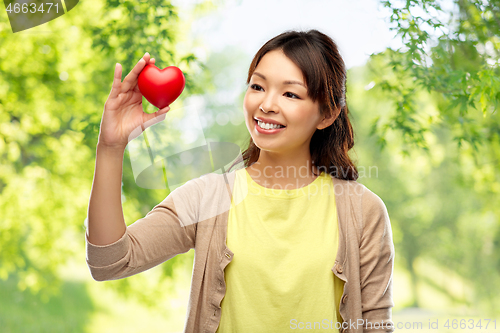 Image of asian woman with red heart over natural background