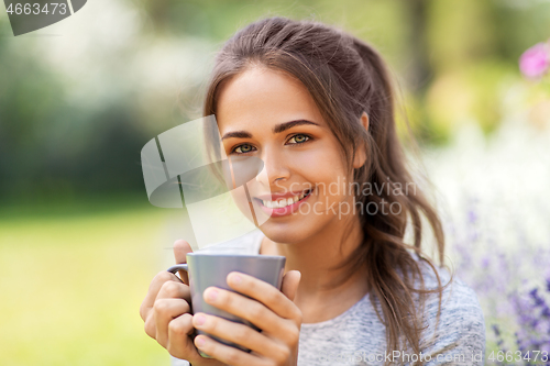 Image of woman drinking tea or coffee at summer garden