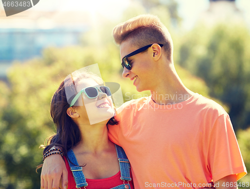 Image of happy teenage couple looking at each other in park