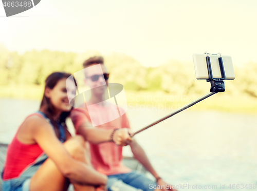 Image of happy teenage couple taking selfie on smartphone