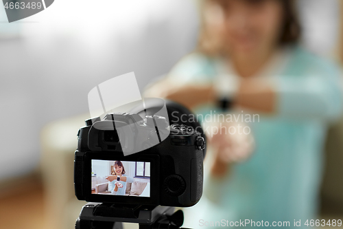 Image of asian blogger makes video blog of smart watch