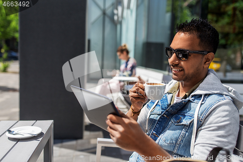 Image of man with tablet pc drinking coffee at street cafe