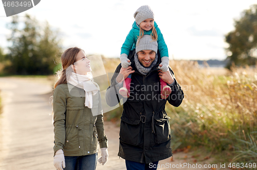 Image of happy family walking in autumn