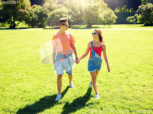 Image of happy teenage couple walking at summer park