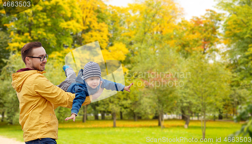 Image of father with son playing and having fun in autumn