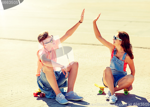 Image of teenage couple with skateboards on city street