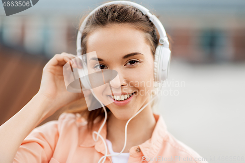 Image of portrait of teenage girl in headphones in city