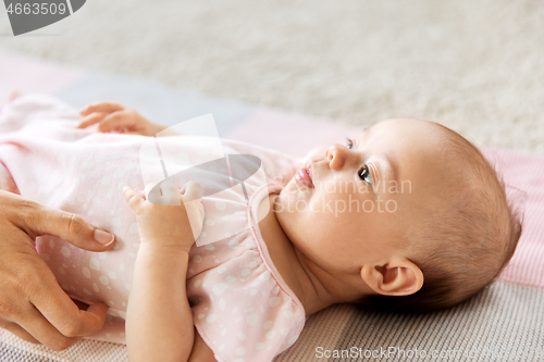 Image of baby girl lying on blanket and mother\'s hand