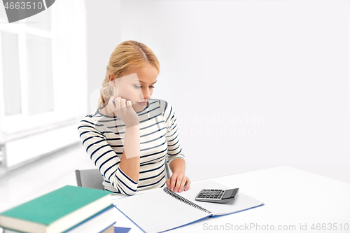 Image of student woman with books writing to notebook