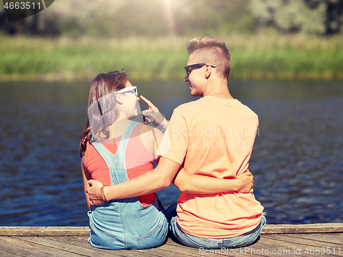 Image of happy teenage couple hugging on river summer berth