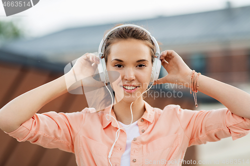 Image of happy teenage girl with headphones in city