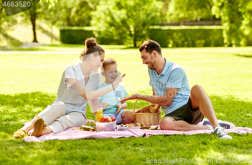 Image of happy family having picnic at summer park