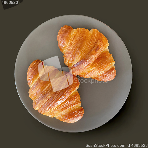 Image of two fresh croissants on grey plate