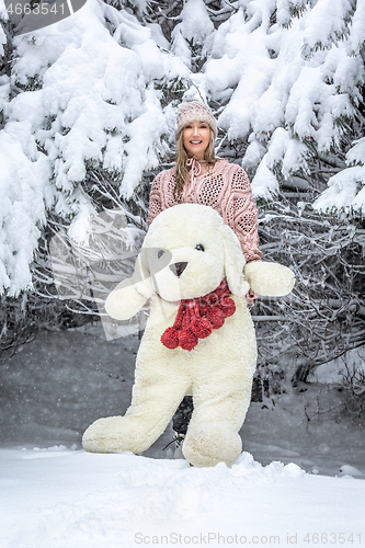 Image of Woman out in the snow with a large soft toy