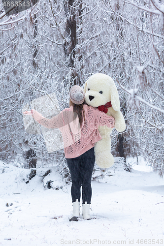 Image of Woman standing in the snow covered pine forest in winter