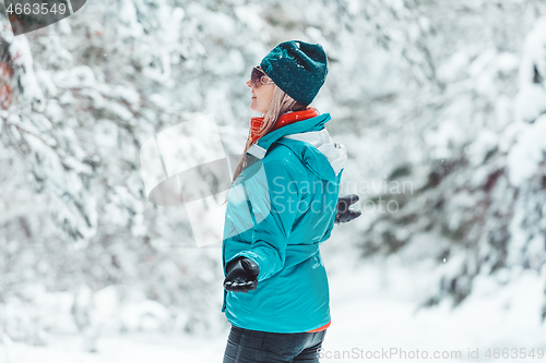 Image of Woman standing out in falling snow in winter