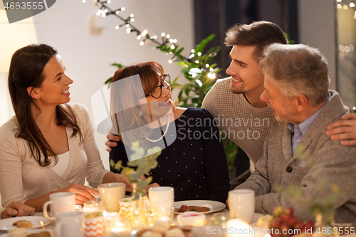 Image of happy family having tea party at home