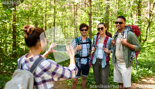 Image of friends with backpacks being photographed on hike