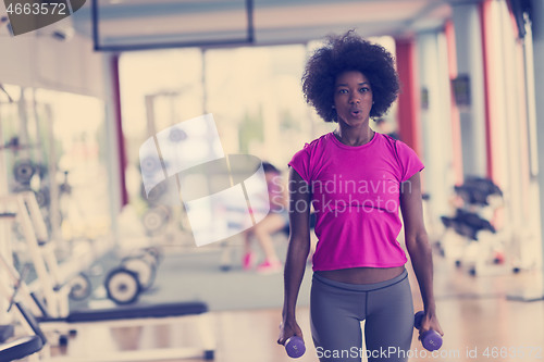 Image of woman working out in a crossfit gym with dumbbells