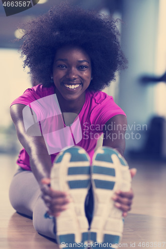 Image of woman in a gym stretching and warming up before workout