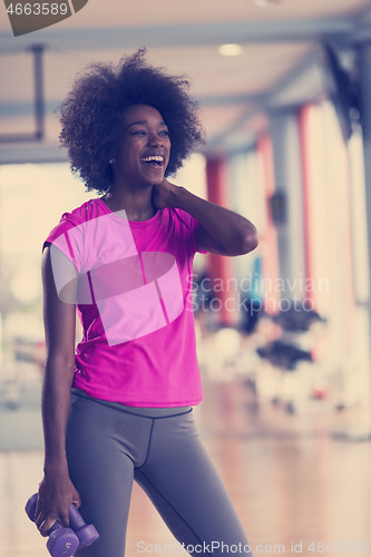 Image of woman working out in a crossfit gym with dumbbells