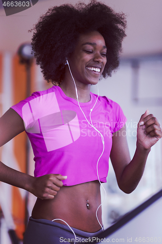 Image of afro american woman running on a treadmill