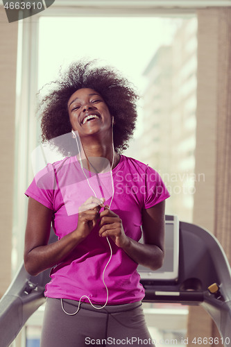 Image of afro american woman running on a treadmill