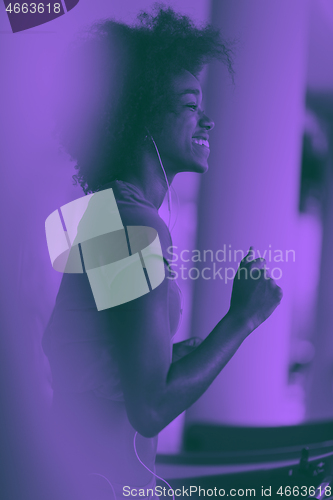 Image of afro american woman running on a treadmill