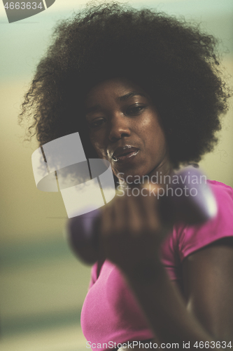 Image of woman working out in a crossfit gym with dumbbells