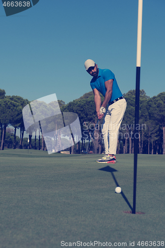 Image of golf player hitting shot at sunny day