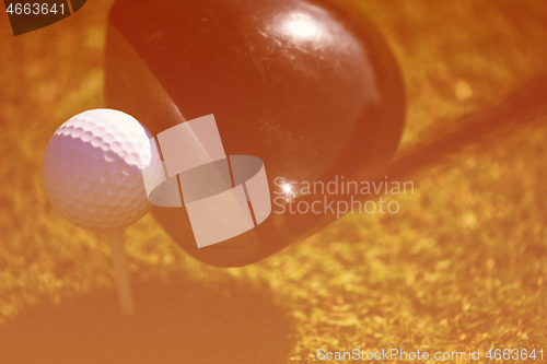 Image of top view of golf club and ball in grass