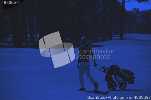 Image of golf player walking with wheel bag