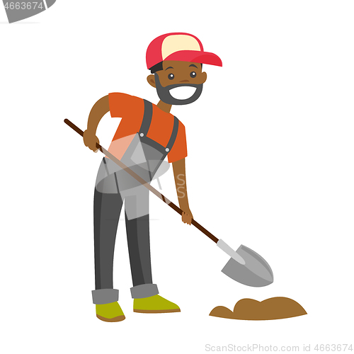 Image of A happy black farmer with a shovel on a farm field.