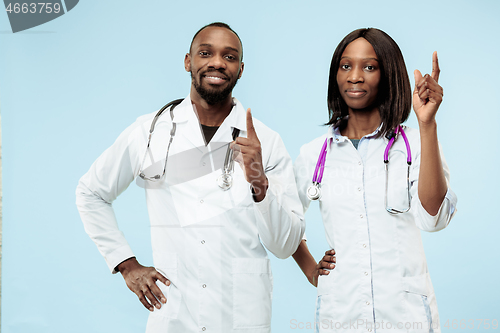 Image of The female and male happy afro american doctors on blue background