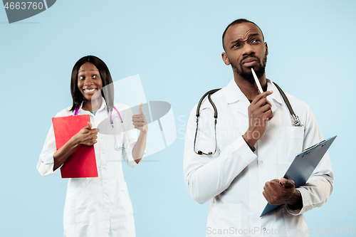 Image of The female and male happy afro american doctors on blue background