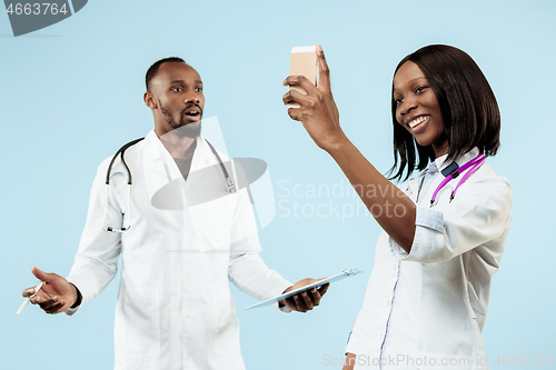 Image of The female and male happy afro american doctors on blue background