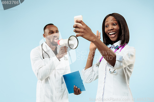 Image of The female and male happy afro american doctors on blue background