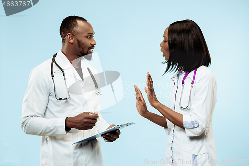 Image of The female and male happy afro american doctors on blue background