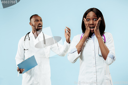 Image of The female and male happy afro american doctors on blue background