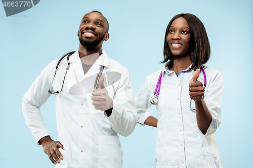 Image of The female and male happy afro american doctors on blue background